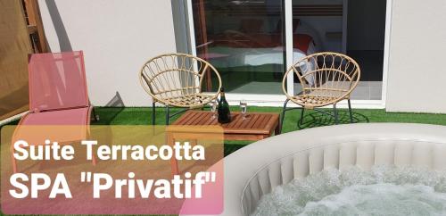 two chairs sitting on a patio with a table at Les Suites du XV in Cap d'Agde