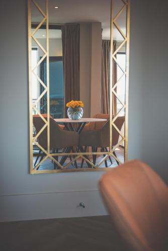 a room with a table and chairs and a mirror at NOVU Apartments Liverpool Waterfront in Liverpool