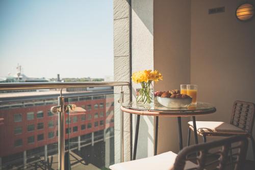 a table with a bowl of fruit and flowers on a balcony at NOVU Apartments Liverpool Waterfront in Liverpool