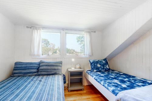 two beds in a small room with a window at Black Cove Cottage in Manchester