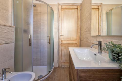 Un baño con dos lavabos y una ducha. en Pufferfish Apartment with private terrace, en Alghero
