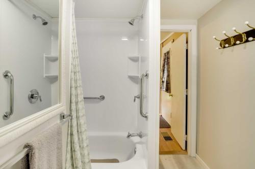 a white bathroom with a shower and a tub at Peaceful Fishermans Paradise with Deck and Fire Pit! in Winthrop