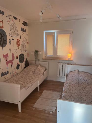 Apartament w Zdroju في بوسكو ازدروي: غرفة نوم صغيرة بسريرين ونافذة