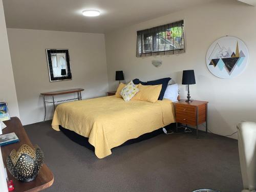 a bedroom with a bed and a table and a mirror at Absolute Bliss Apartments in Paihia