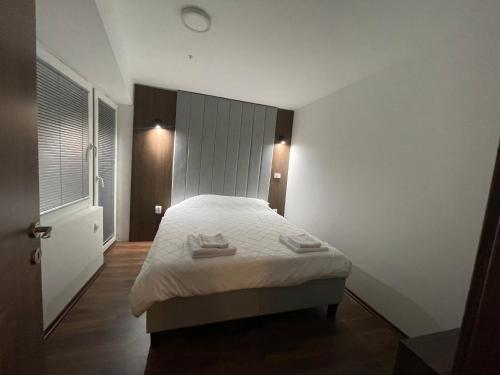 a bedroom with a white bed with two towels on it at Skopje Kale Luxury Apartment in Skopje