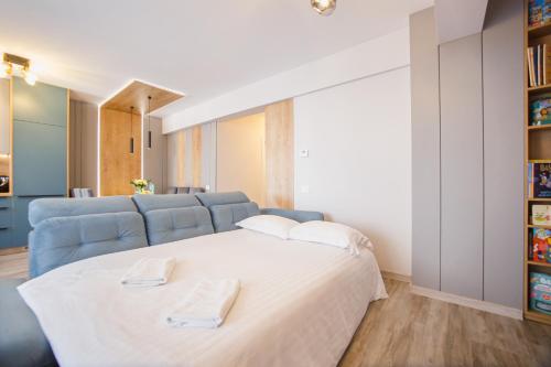 a bedroom with a bed and a blue couch at Charming Family Haven in Oradea