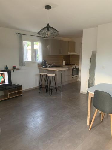 un salon avec une table et une cuisine dans l'établissement Maison J&J, à Porto-Vecchio