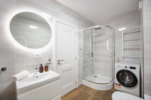 a white bathroom with a shower and a sink at Charming Family Haven in Oradea