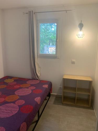 une petite chambre avec un lit et une fenêtre dans l'établissement Maison J&J, à Porto-Vecchio