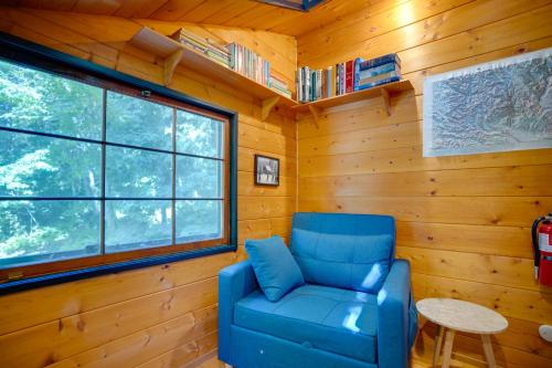 a blue chair in a room with a window at Leavenworth Cabin with Private Hot Tub! in Leavenworth