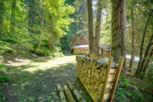 a log fence in front of a house in the woods at Leavenworth Cabin with Private Hot Tub! in Leavenworth