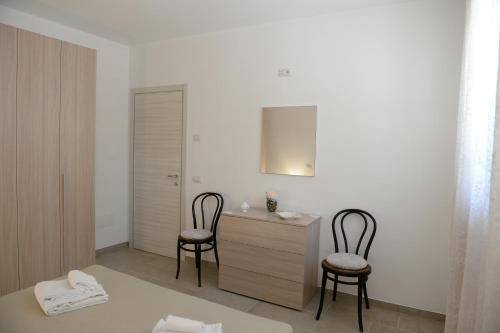 a bedroom with two chairs and a desk and a bed at Il Giardino dei Ricordi in Alberobello