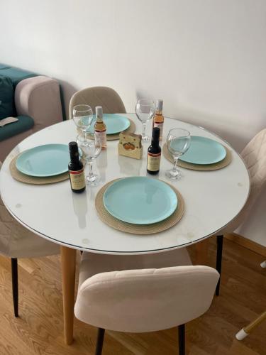 a white table with two plates and wine glasses at Apartman Iva in Tivat