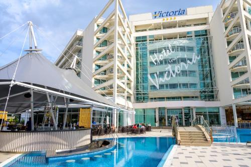 a hotel with a swimming pool in front of a building at Effect Grand Victoria Hotel - Ultra All Inclusive in Sunny Beach