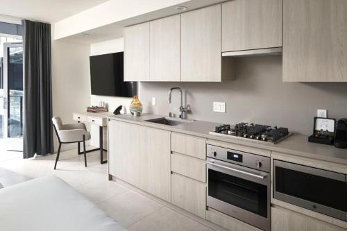 a kitchen with white cabinets and a stove top oven at Level Chicago Fulton Market in Chicago