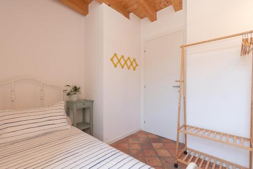 a white bedroom with a bed and a door at La Piazzetta in Iseo