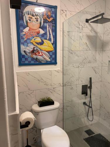 a bathroom with a movie poster and a toilet at Centrally Located Room - 5 in Port Antonio