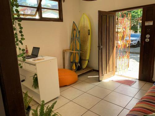 Habitación con escritorio y tablas de surf en la pared. en Rudá Hostel, en Itacaré