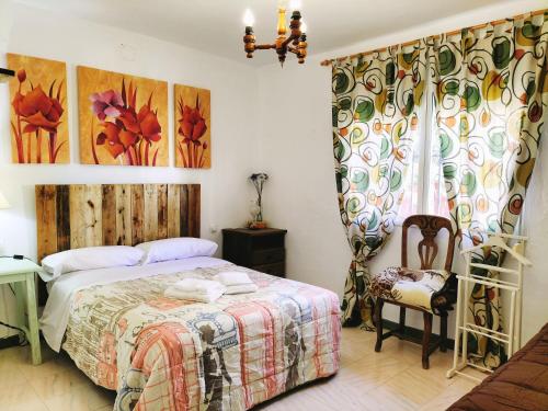 1 dormitorio con 1 cama y 1 silla en El Capricho, en Benalup-Casas Viejas