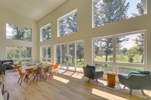 a living room with large windows and a table and chairs at Columbia Falls Home with Patio Near Glacier NP! in Columbia Falls