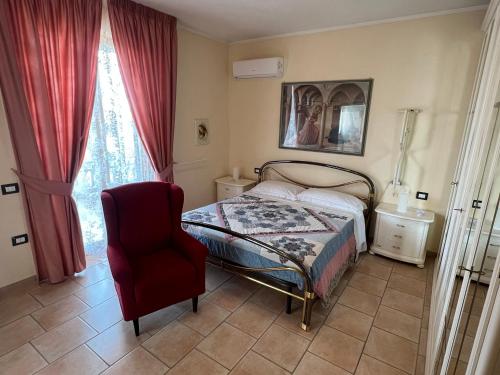 a bedroom with a bed and a chair and a window at Le Calende di Maggio di Assisi in Palazzo