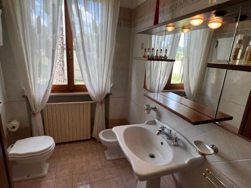 a bathroom with a sink and a toilet and a mirror at Le Calende di Maggio di Assisi in Palazzo