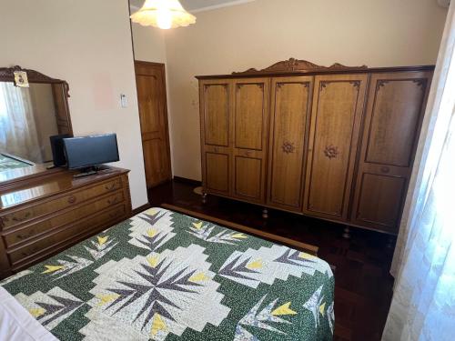 a bedroom with a bed and wooden cabinets and a television at Le Calende di Maggio di Assisi in Palazzo