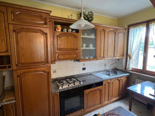 a kitchen with wooden cabinets and a sink at Le Calende di Maggio di Assisi in Palazzo
