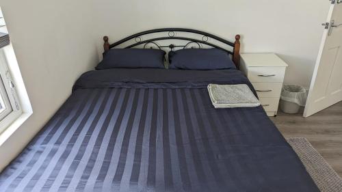 un letto con lenzuola blu e cuscini blu in una camera da letto di RAHAL EASTHAM a Londra