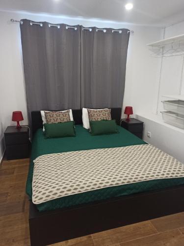 a bedroom with a large bed with green and white sheets at AL Rosa Esperança in Angra do Heroísmo
