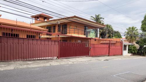 a red fence in front of a house at Belen Suites in San Antonio