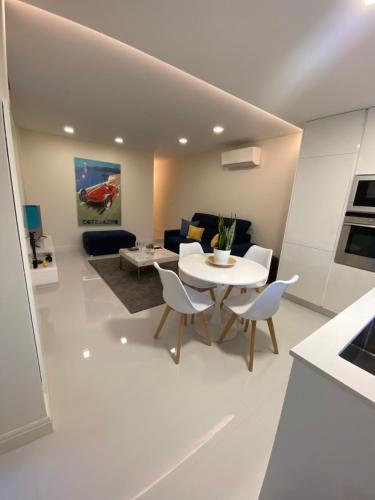 a white living room with a table and chairs at Logement aux portes de Monaco Cap D Ail in Cap d'Ail