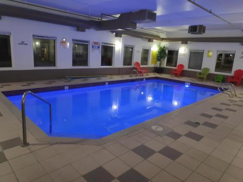 a large pool with blue water in a building at Super 8 by Wyndham Hinton in Hinton