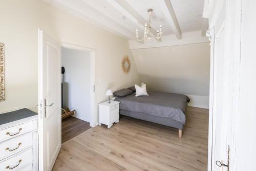 a bedroom with a bed and a chandelier at Romantik-Home Nordelsass - Ferienwohnung für Selbstversorger in Oberhoffen-lès-Wissembourg