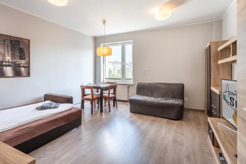 - une chambre avec un lit, une chaise et une table dans l'établissement Apartament Sweet, à Gdynia