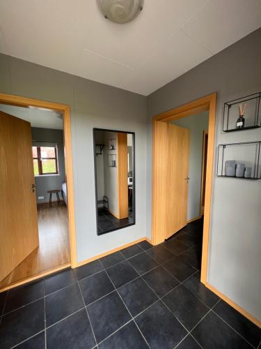 a living room with two mirrors and a tile floor at Fíflholt in Hvolsvöllur