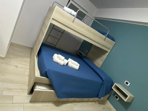Habitación con 1 cama azul y 2 toallas blancas. en La casa dell’Aurora, en Falcone
