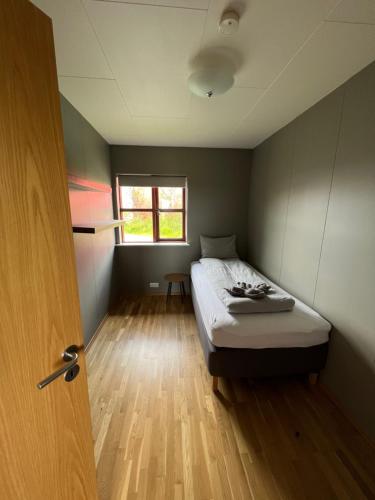 a small bedroom with a bed and a window at Fíflholt in Hvolsvöllur