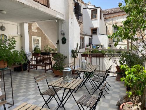 an outdoor patio with tables and chairs and plants at Stanze al Genio B&B in Palermo