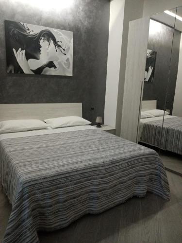 a bedroom with a large bed and a mirror at Sa Benedica - Luxury House in Calatabiano