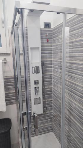 a shower with a glass door in a bathroom at Sa Benedica - Luxury House in Calatabiano