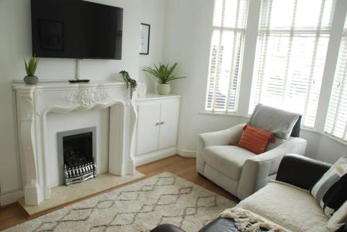 a living room with a fireplace with a tv above it at Entire house, Waterloo, free street parking in Waterloo
