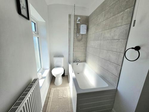 a bathroom with a toilet and a tub and a sink at Entire house, Waterloo, free street parking in Waterloo