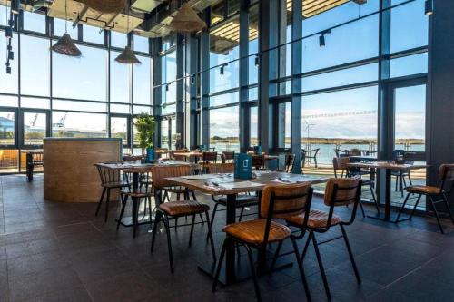 a restaurant with tables and chairs and large windows at Entire house, Waterloo, free street parking in Waterloo