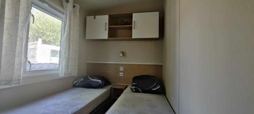 GastesにあるMH829-My beautiful homeのベッド2台と窓が備わる小さな客室です。