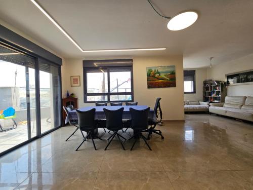 uma sala de estar com mesa e cadeiras em פנטהאוז ברמה em Bete-Semes