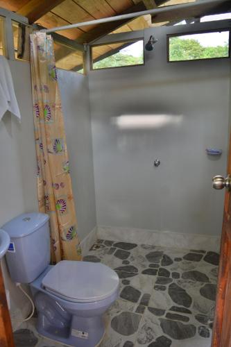 La salle de bains est pourvue de toilettes et d'un rideau de douche. dans l'établissement Posada Nativa El Esfuerzo 2, à Nuquí