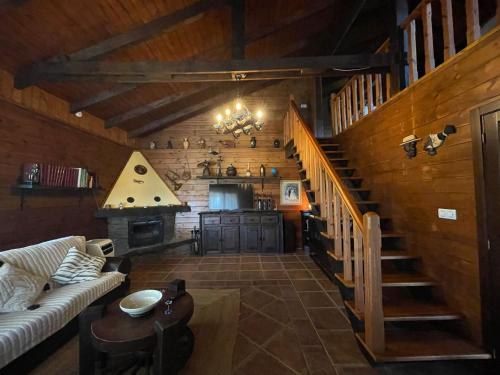 una sala de estar con una escalera en una casa de madera en VILLA LAURA en Salceda