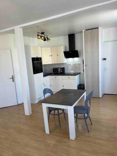 une cuisine avec une table et des chaises dans une pièce dans l'établissement Le Saint Joseph, à Châlons-en-Champagne