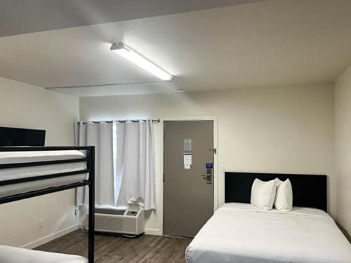 ein Schlafzimmer mit einem Bett und eine Tür mit einem Fenster in der Unterkunft Pasco WA in Pasco